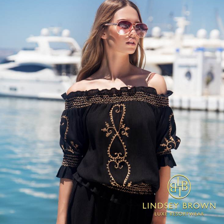 Casey Batchelor wears black designer bardot top by Lindsey Brown resort wear