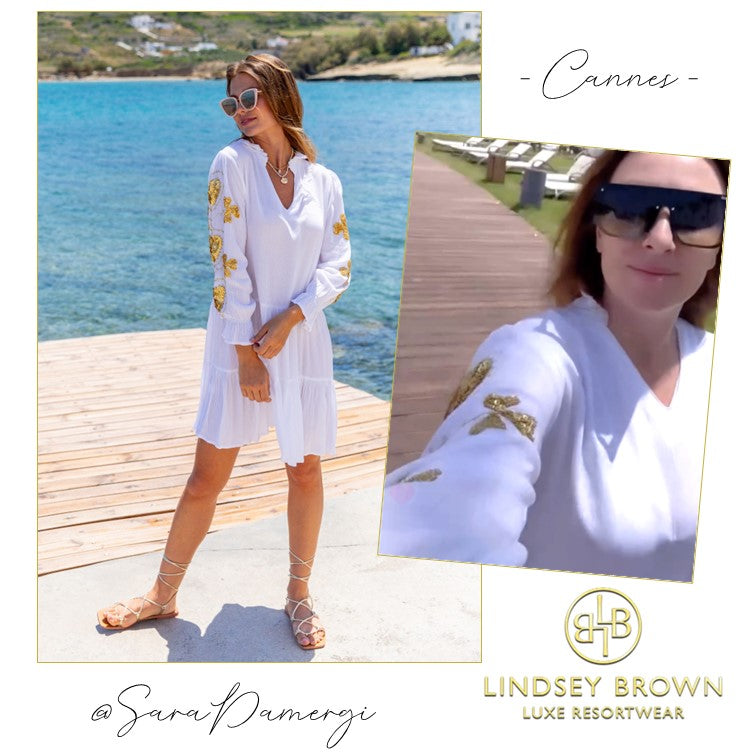 Sara Damergi wears white gold holiday dress on A Place in the Sun TV