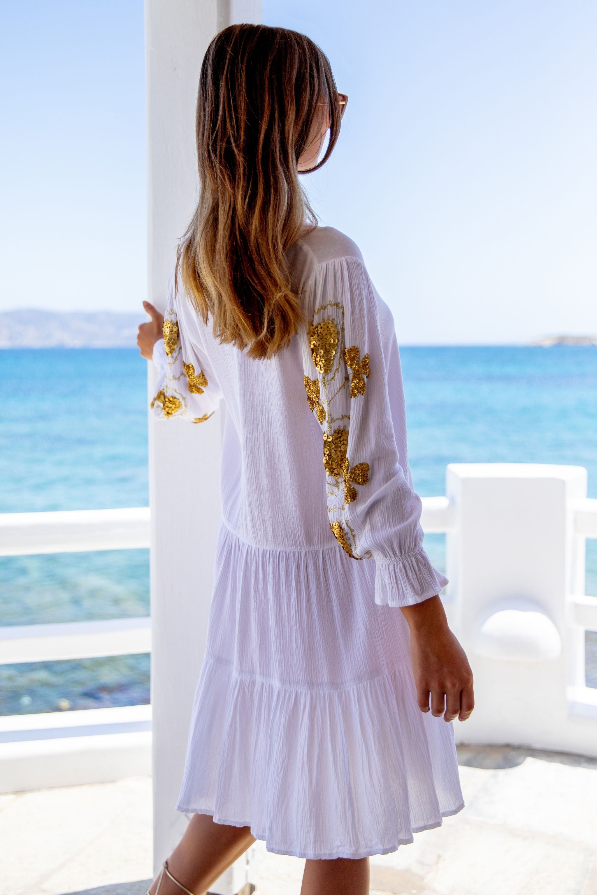 White cotton beach dress with gold embroidery by Lindsey Brown resort wear
