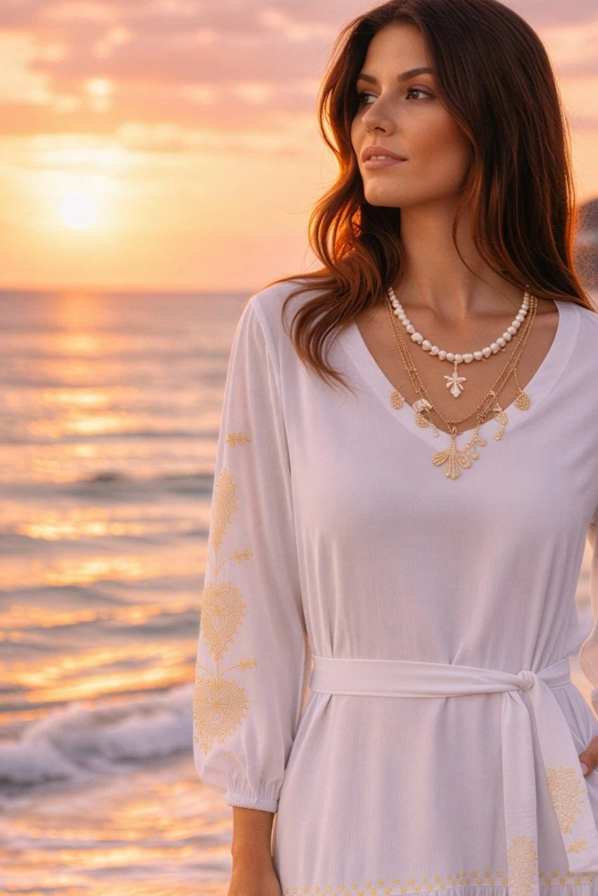 white v neck cotton beach dress with long sleeves and gold sleeve embroidery and wear with the matching belt