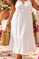 Lindsey Brown plus size luxury white cotton midi length beach dress, close up image , featuring a flattering V-neck, and tassels on the neckline.