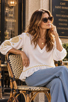 white v neck cotton blouse with gold embroidery by Lindsey Brown