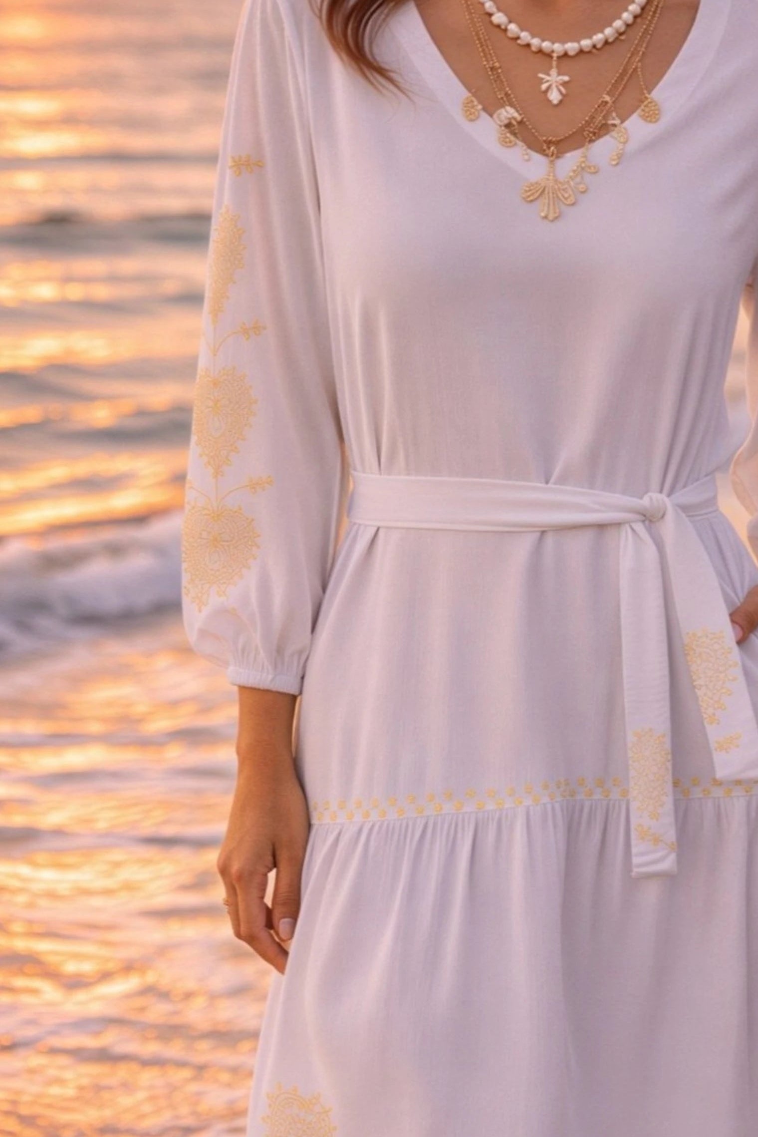 white long sleeved cotton beach dress with gold sleeve motifs to wear in summer on holiday 